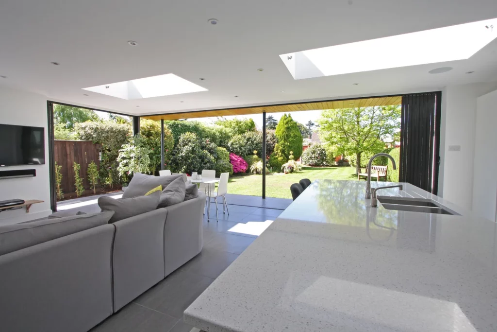 Open plan kitchen with bifold doors and white furniture