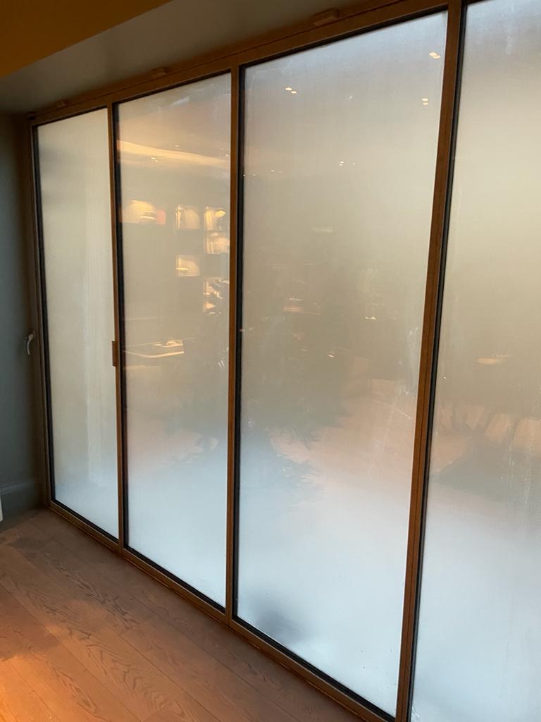 Frosted internal bifold doors with glass in a bathroom